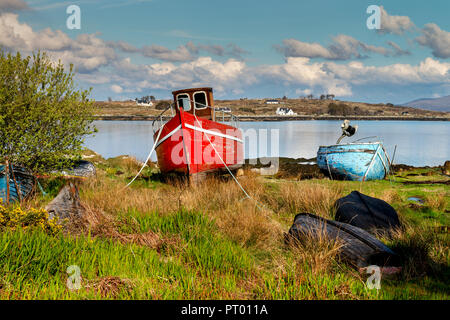 Roundstone, Connemara, Galway, Irland, 04/2018, heruntergekommene Fischerboote links nach Verfall neben der Bucht von Connemara. Stockfoto