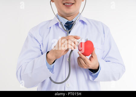 Männlicher Arzt in weiße Uniform halten und Stethoskop verwenden bis zu Herz rot Spielzeug Herzen prüfen. Cardio therapeutist, Arzt, Herz, Herz Ratte Stockfoto