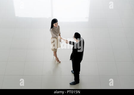 Blick von oben auf die asiatische Geschäftsmann und Geschäftsfrau Hände schütteln im Büro Lobby. Zu den Business willkommen. Stockfoto
