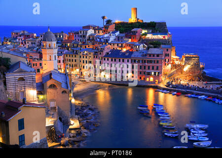 Luftaufnahme von Vernazza vilagge leuchtet in der Dämmerung auf der mediterranen Küste, Cinque Terre, Italien Stockfoto