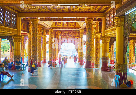 YANGON, MYANMAR - Februar 27, 2018: Die Treppe entlang der East Gate galerie Shwedagon Pagode mit herrlichem Interieur, mit geschnitzten Holzmöbeln dekoriert, um ein Stockfoto