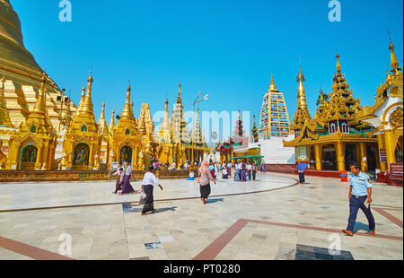 YANGON, MYANMAR - Februar 27, 2018: Touristen und Pilger besuchen Shwedagon Pagode, berühmt für seine herausragende Architektur, zahlreiche religiöse Objekte Stockfoto