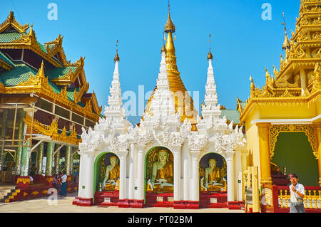 YANGON, MYANMAR - 27. FEBRUAR 2018: Die atemberaubende Schrein mit Bilder von Buddha, berühren die Erde, mit feinen Stuckarbeiten dekoriert und gekrönt mit kolbenringein Stockfoto