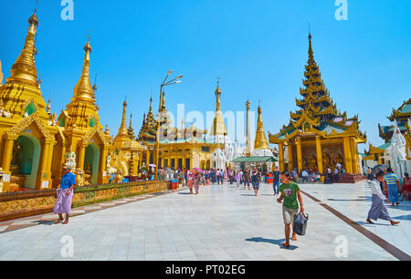 YANGON, MYANMAR - Februar 27, 2018: Das Gebiet der Shwedagon Pagode mit malerischen Pavillons und goldenen Stupas Stockfoto