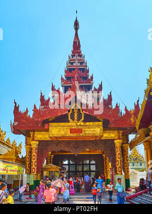 YANGON, MYANMAR - 27. FEBRUAR 2018: Die Masse der Touristen und Pilger an der Ostern Treppe von der Shwedagon Pagode, mit verzierten Säulen geschmückt und Stockfoto