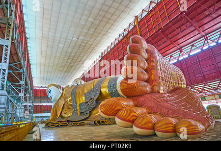 YANGON, MYANMAR - 27. FEBRUAR 2018: Die Spuren von Chaukhtatgyi Liegenden Buddha in Tempel, mit goldenen Mustern verziert, am 27. Februar in Yang Stockfoto