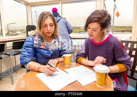 Zwei Frauen Unterzeichnung Formen in einem Cafe, Irland Stockfoto