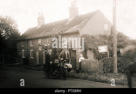 Mann auf Veteran Motorräder & Beiwagen außerhalb Cottages angezeigte Lyons & Brooke Bond Tea & BP Geist, ca. 1910/15 Stockfoto