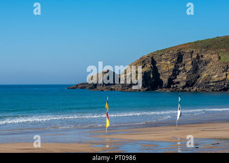 Flags, die die Präsenz von Rettungsschwimmern auf Praa Sands Beach zu zeigen. Die Bucht ist an der südlichen Küste von Cornwall und zieht Schwimmer und Surfer. Stockfoto