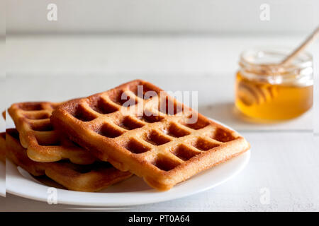 Wiener und Belgische Waffeln mit Honig Stockfoto