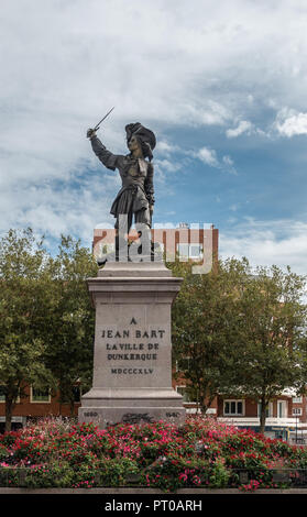 Dunkerque, Frankreich - 16. September 2018: Jean Bart, berühmten Piraten, auf seinem Platz in Dünkirchen mit roten Blüten vor unter blauen Himmel mit weißen Wolken. Stockfoto