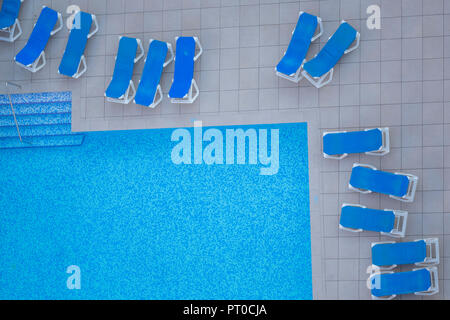 Ein Swimmingpool mit Liegestühlen in der Ansicht von oben. Stockfoto