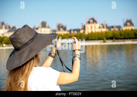 FONTAINBLEAU, Frankreich - 28. August 2017: Junge Frau Touristen fotografieren mit photocamera Schloss Fontainebleau, Frankreich Stockfoto