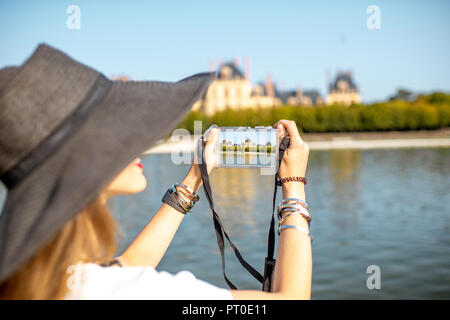 FONTAINBLEAU, Frankreich - 28. August 2017: Junge Frau Touristen fotografieren mit photocamera Schloss Fontainebleau, Frankreich Stockfoto