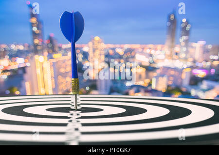 Ziel und das Ziel das Konzept, Blue Dart mit an Bord Nacht Stadt Hintergrund Stockfoto