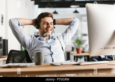 Lächelnd Office Manager reden über Kopfhörer mit Mikrofon während der Sitzung durch die Tabelle im Büro Stockfoto