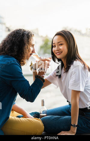 Junges Paar trinken Champagner am Flußufer Stockfoto