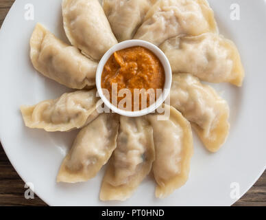 Platte der Nepalesischen Huhn momos und seine achar (Soße) Stockfoto