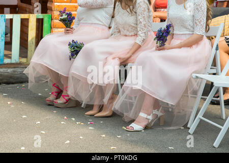 Brautjungfern mit Blumenstrauß auf die Zeremonie. Reihe der Brautjungfern mit Blumensträußen bei der Trauung. Stockfoto
