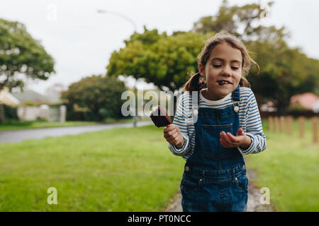 Portrait von niedlichen kleinen Mädchen Eis essen im Freien. Schöne junge Mädchen genießen eine Schokolade, Süßigkeiten, Eis. Stockfoto