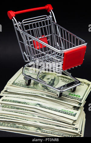 Warenkorb auf Stapel von Banknoten Stockfoto