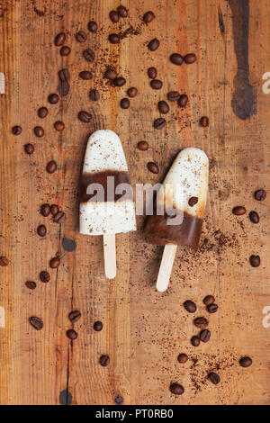 Hausgemachte Espresso-Macchiato Eis am Stiel mit Kaffeebohnen auf hölzernen Hintergrund Stockfoto