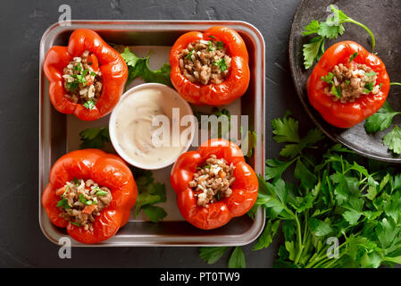 Gebackene Paprika mit Hackfleisch, Reis, Zwiebel auf schwarzem Stein. Ansicht von oben Stockfoto