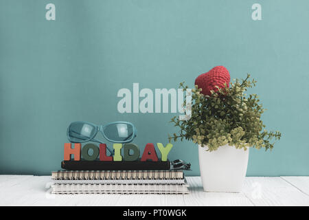 Urlaub Briefe text und Notebook Papier und wenig Deko Baum in weiße Vase auf hölzernen Hintergrund, hallo Wochenende Urlaub Konzept Idee. Stockfoto