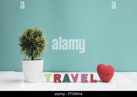 Reisen Buchstaben text und Notebook Papier und wenig Deko Baum in weiße Vase auf hölzernen Hintergrund, Reise Urlaub Konzept Idee. Stockfoto
