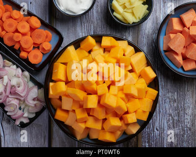 Zutaten für butternut Kürbis Suppe mit Süßkartoffeln und Ingwer, auf Grau rustikaler Hintergrund Stockfoto