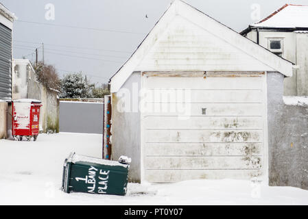 Blick auf die Straße von Mülltonnen durch Schnee in Falmouth, Cornwall. Stockfoto