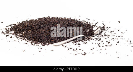 Trockene schwarzer Tee Blätter mit Teelöffel isoliert auf weißem Stockfoto