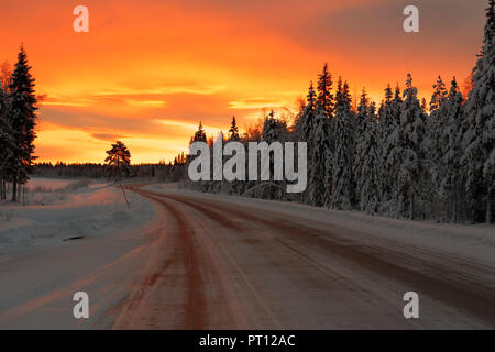 Sonnenaufgang im Winter auf dem Weg von Rovaniemi in Finnland nach Kiruna in Schweden fahren. Stockfoto