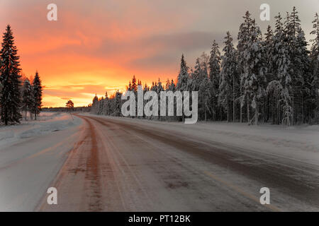 Sonnenaufgang im Winter auf dem Weg von Rovaniemi in Finnland nach Kiruna in Schweden fahren. Stockfoto