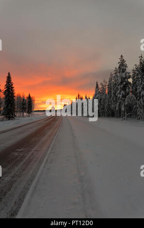 Sonnenaufgang im Winter auf dem Weg von Rovaniemi in Finnland nach Kiruna in Schweden fahren. Stockfoto