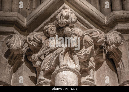 Einen Abschnitt aus einem Fries auf einen der antiken Säulen an der Kathedrale in den Brunnen mit der Darstellung eines Jungen und eines Mannes crumping' Äpfel aus einem Obstgarten. Stockfoto