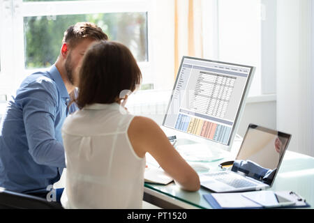 Zwei Geschäftsleute Sitzen im Büro mit Computer und Laptop auf dem Schreibtisch Stockfoto