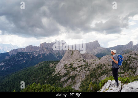 In der wunderschönen alpinen Landschaft eingebettet, ein Mann bewundert die hochalpine Landschaft mit Bergen und bewölktem Himmel. Stockfoto