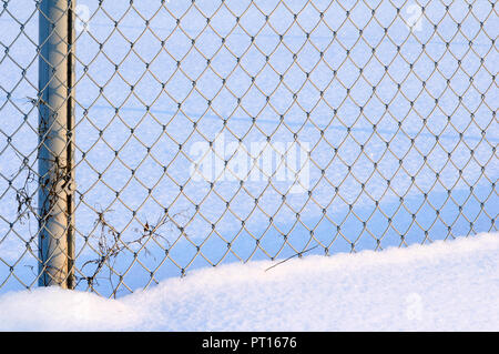 Details Verzinkter Maschendrahtzaun im Schnee. Kalten Wintertag. Stockfoto