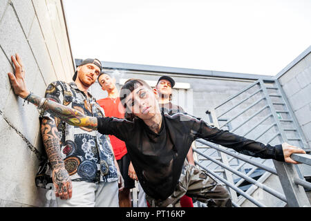 Gruppe von jungen Rapper auf dem Metall Treppe von einem verlassenen Gebäude posing Stockfoto