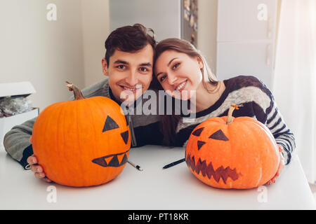 Junges Paar, Jack-o-Lantern für Halloween auf Küche. Glücklich der Mann und die Frau bereit Kürbisse für Urlaub. Dekoration Stockfoto