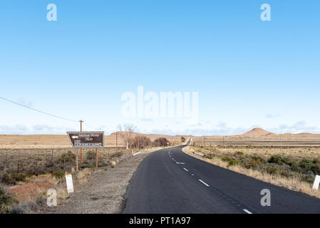 VICTORIA WEST, SÜDAFRIKA, 7. AUGUST 2018: Landschaft auf der Straße R63 zwischen Victoria West und Loxton in der Northern Cape Provinz. Eine direktionale Zeichen Stockfoto