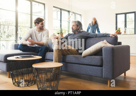 Sohn sitzen auf der Couch, im Gespräch mit seinem Vater Stockfoto