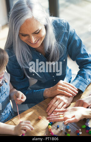 Großmutter und Enkelin und Mutter Gewinde Perlen Stockfoto