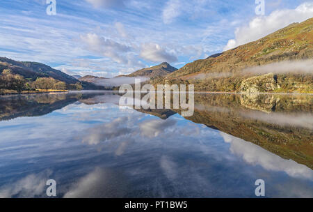 Reflexionen in Llyn Gwynant an einem nebligen Morgen im glaslyn Tal nach Westen mit Yr Aran Berg im Hintergrund Snowdonia National Park Stockfoto