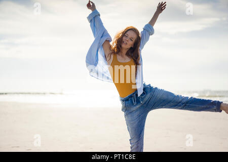 Glückliche Frau Spaß am Strand, springen in die Luft, Stockfoto