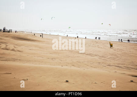 Menschen zu Fuß und Kitesurfen an der Nordsee Strand von Noordwijk aan Zee, Niederlande. Stockfoto