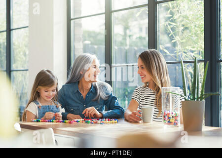 Großmutter und Enkelin und Mutter Gewinde Perlen Stockfoto