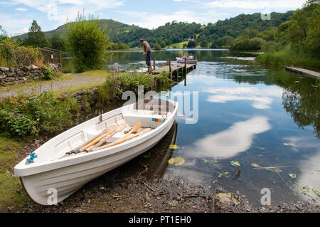 Weiß rudern schmuddelig, zog hoch aus dem Wasser auf den Strand von Lake District noch See als perfekte Spiegel für den Sommer Himmel. Stockfoto