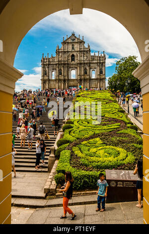 Macau, China - Juli 11, 2014: Schöne Aussicht auf die berühmten Wahrzeichen der Ruinen von St. Paul durch einen Bogen. Viele Touristen stehen auf der Treppe... Stockfoto